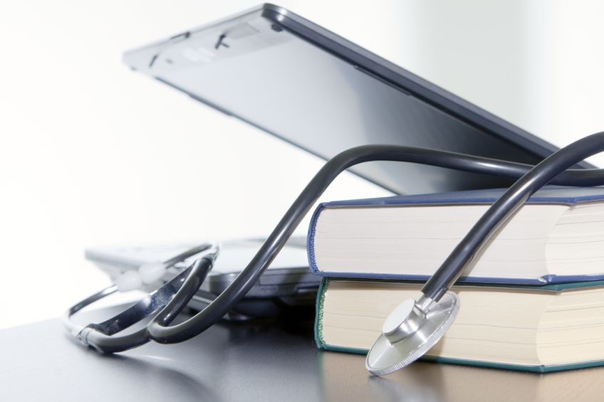 Medical stethoscope and laptop and books