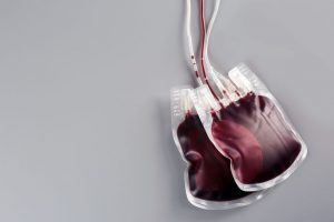 Blood packs on gray background, top view with space for text. Donation day Blood packs
